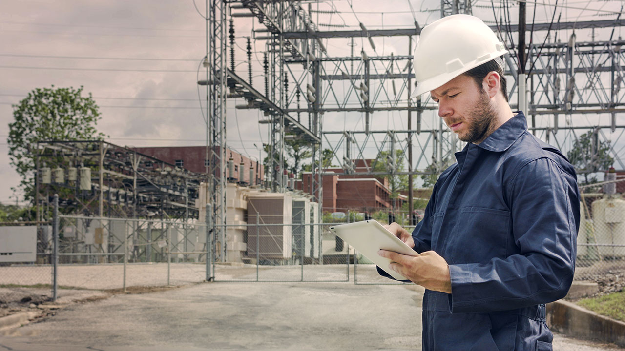 Security technician checking infrastructure details while onsite at a local power grid.