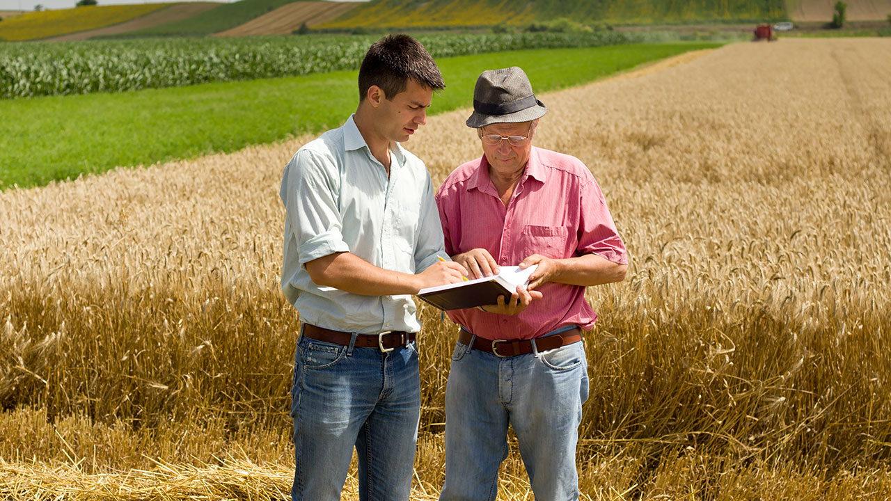 Young man reviewing the crop history of a local farm with the farm's owner.
