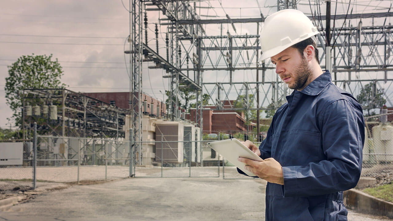 Young man checking security protocols on-site at an electrical grid.