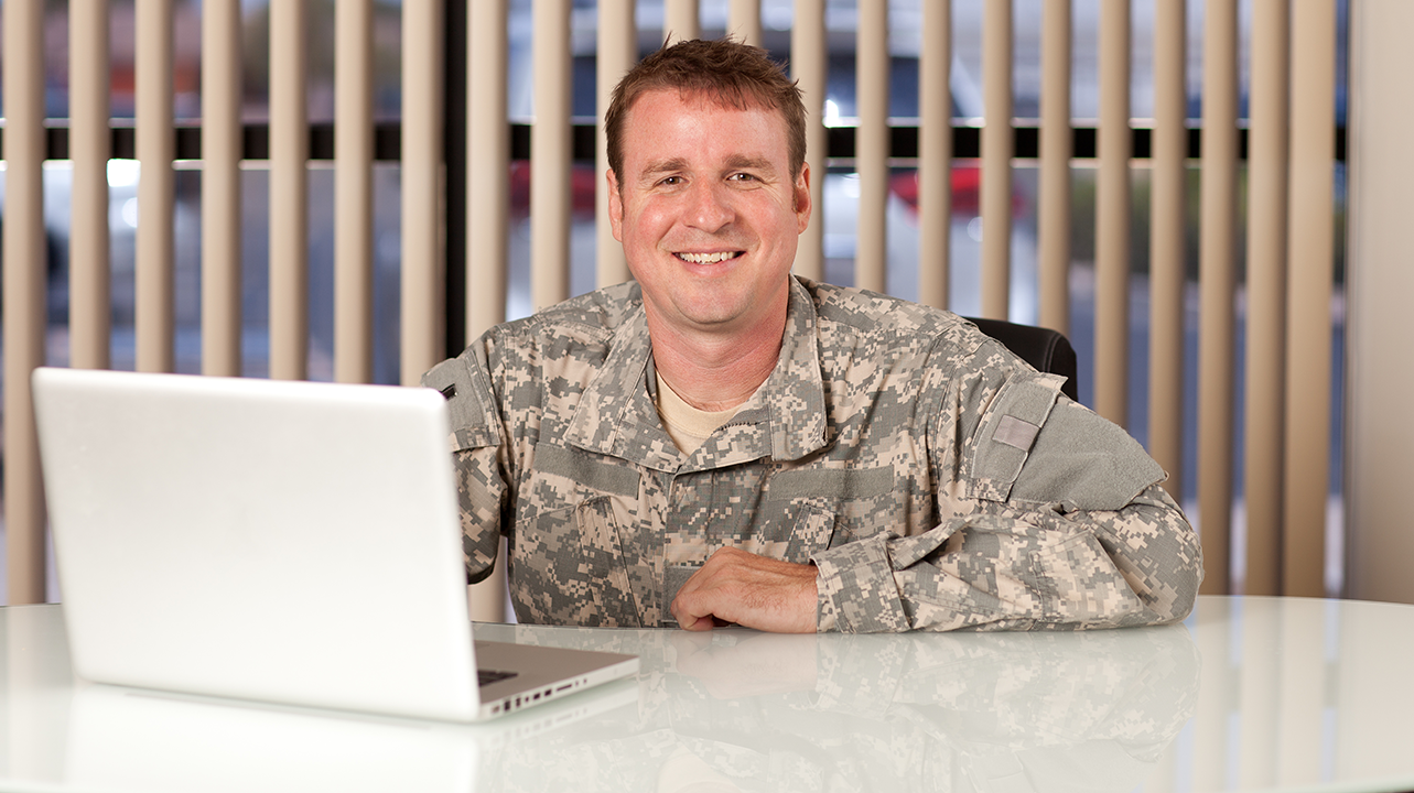 Photo of man in fatigues at desk