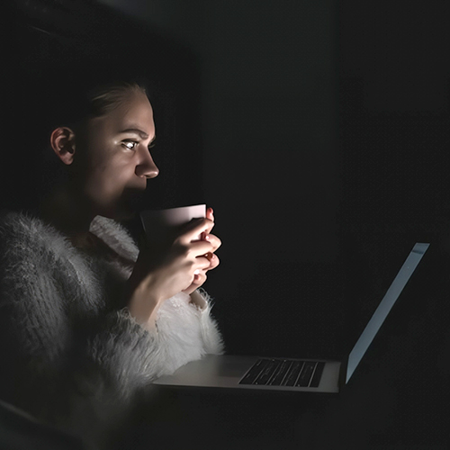 A spooky photo of a student taking an online course in the dark